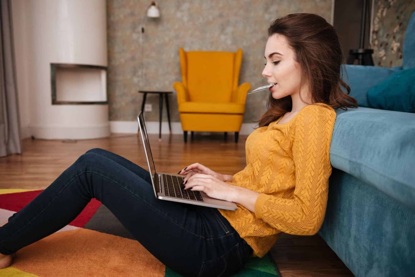 girl on her laptop about to make a purchase with her card