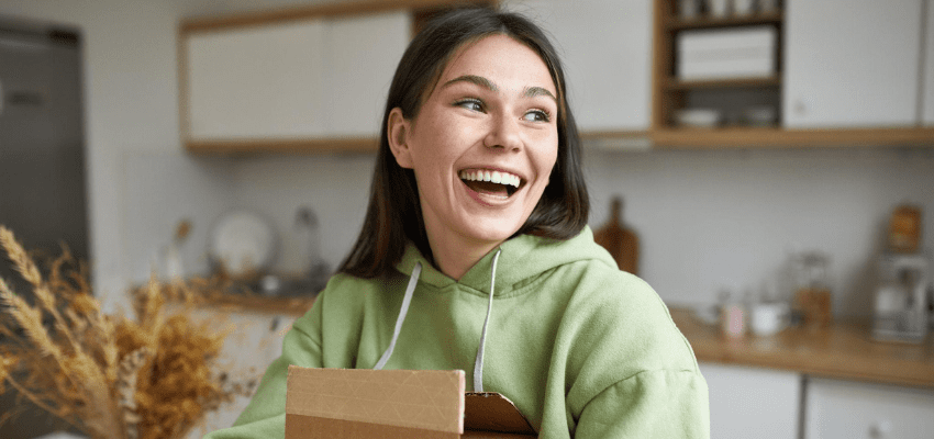 girl holding cardboard boxes and smiling