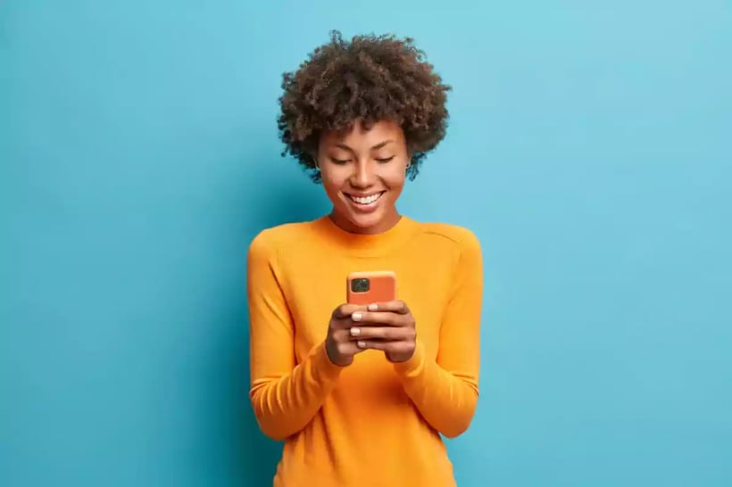 Smiling woman using a phone.