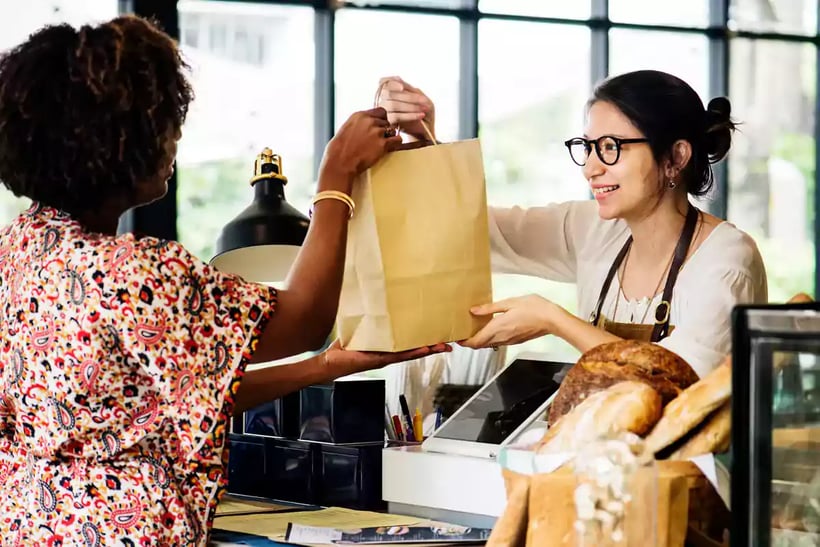 Woman purchasing items in a store.