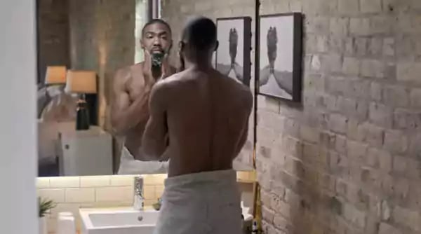 Man looking at his face in a mirror.