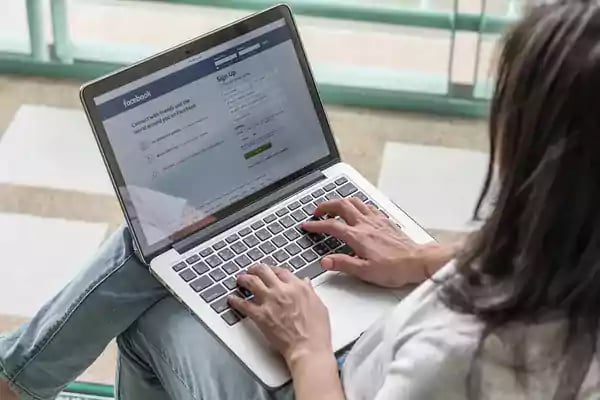 Woman typing on a laptop computer.