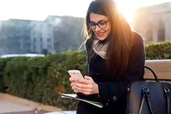 Backlit woman using smartphone