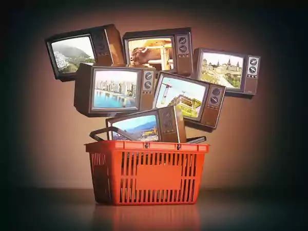 Multiple t.v.s in a shopping basket.