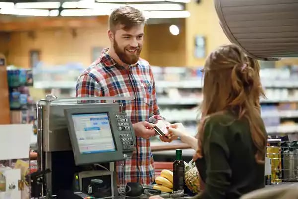 Bearded man paying for groceries