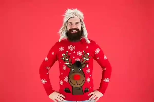 Smiling man wearing a reindeer sweater.