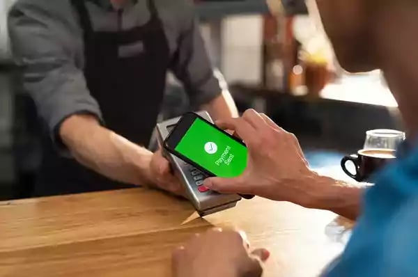 Person paying for goods with their phone.
