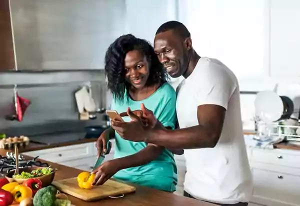 Couple cooking together, taking a selfie.