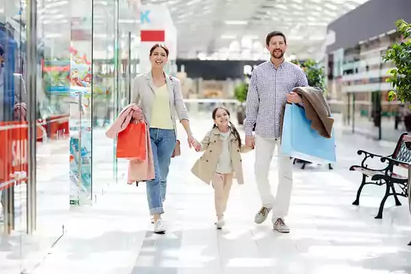 Family shopping in a mall with multiple shopping bags.