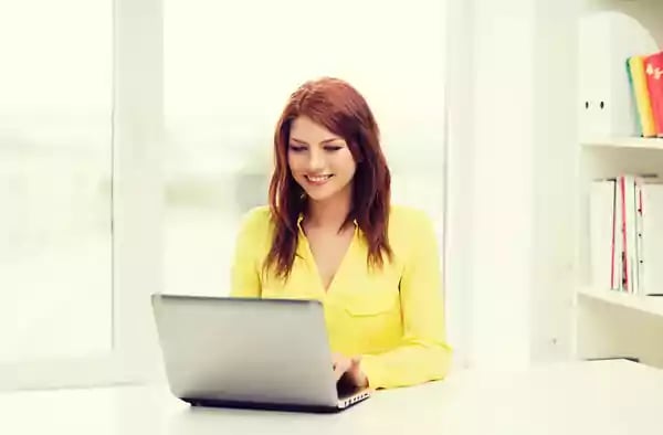 Woman typing on a laptop computer.