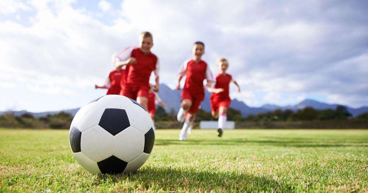 kids playing soccer in an open field-1