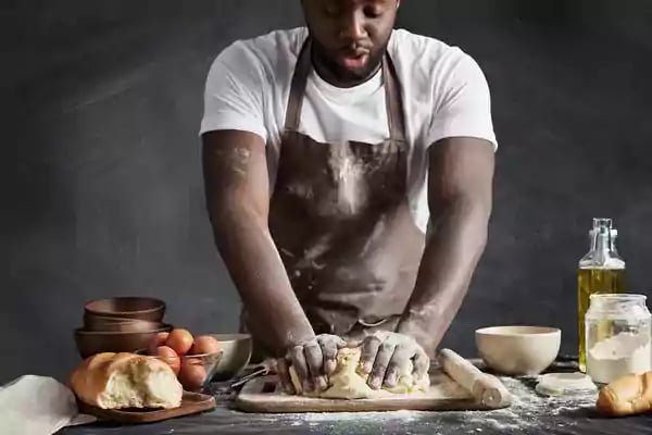 Baker kneading dough.