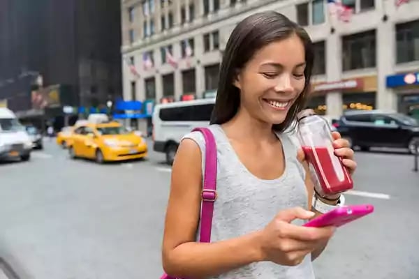 Woman smiling while using her mobile phone.