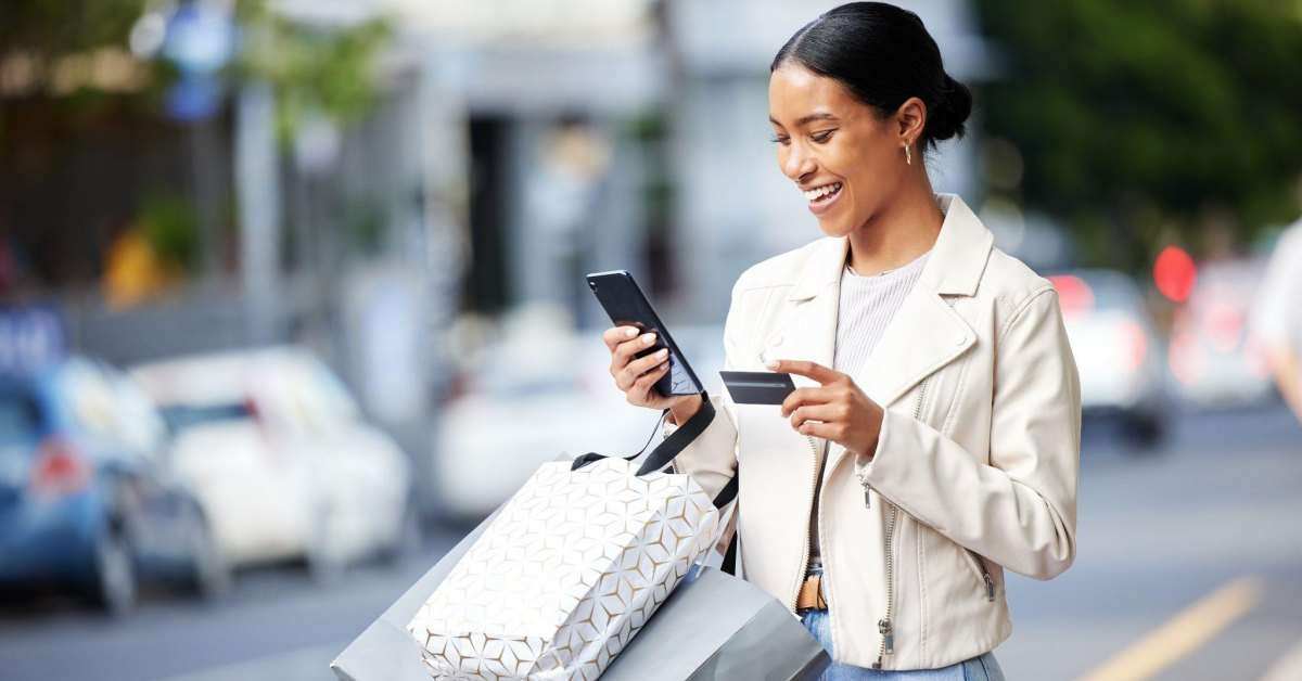 woman in the street shopping on her phone