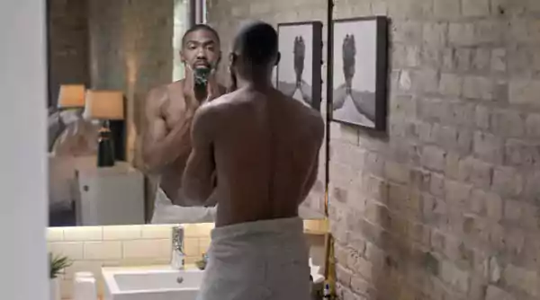 Man looking at his face in a mirror.