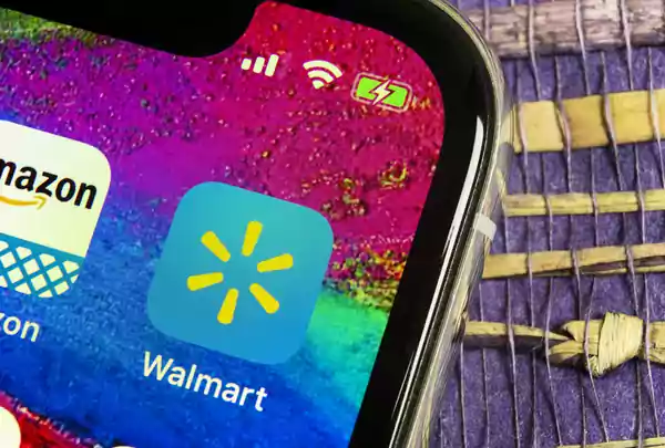 Phone with Walmart and Amazon icons on display.