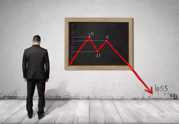 sad businessman falling price graph